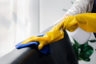 janitor, cleaner wiping down back of leather chairs